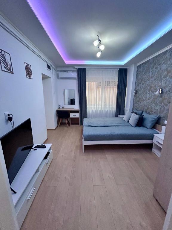 a bedroom with a blue bed and a purple ceiling at Belien Apartman in Makó