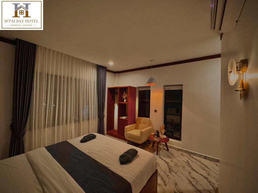 a hotel room with a bed and a chair at M'pai Bay Hotel in Koh Rong Sanloem