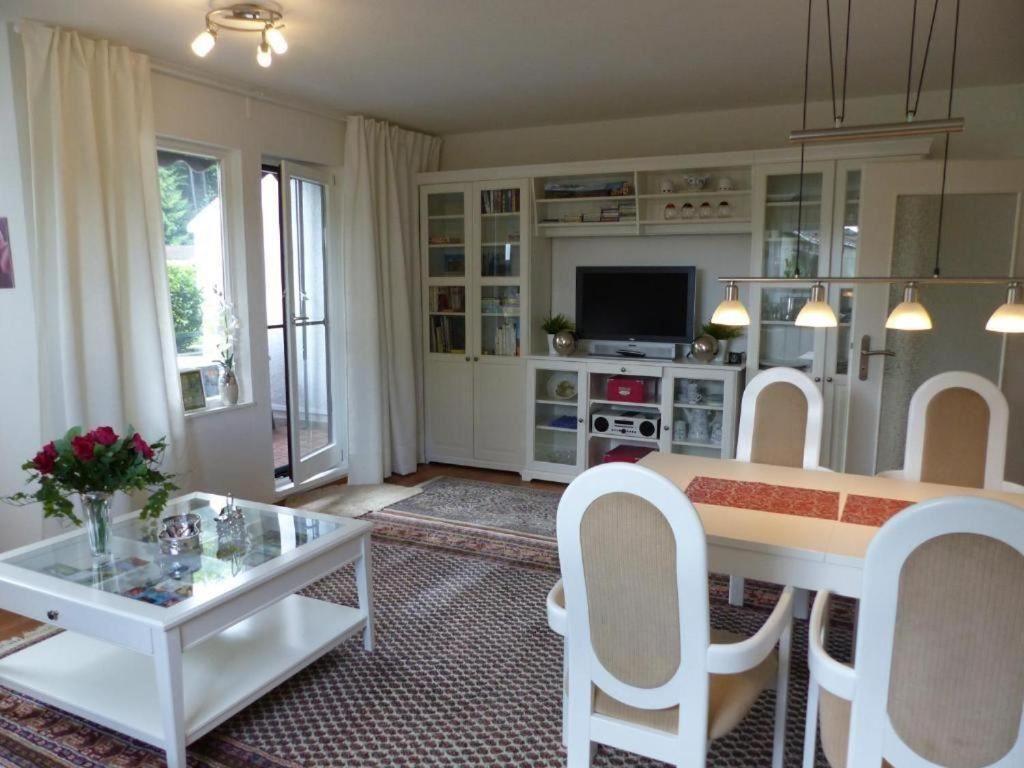 a living room with a table and white chairs at FeWo Parkblick mit 2 Bädern in Bad Harzburg