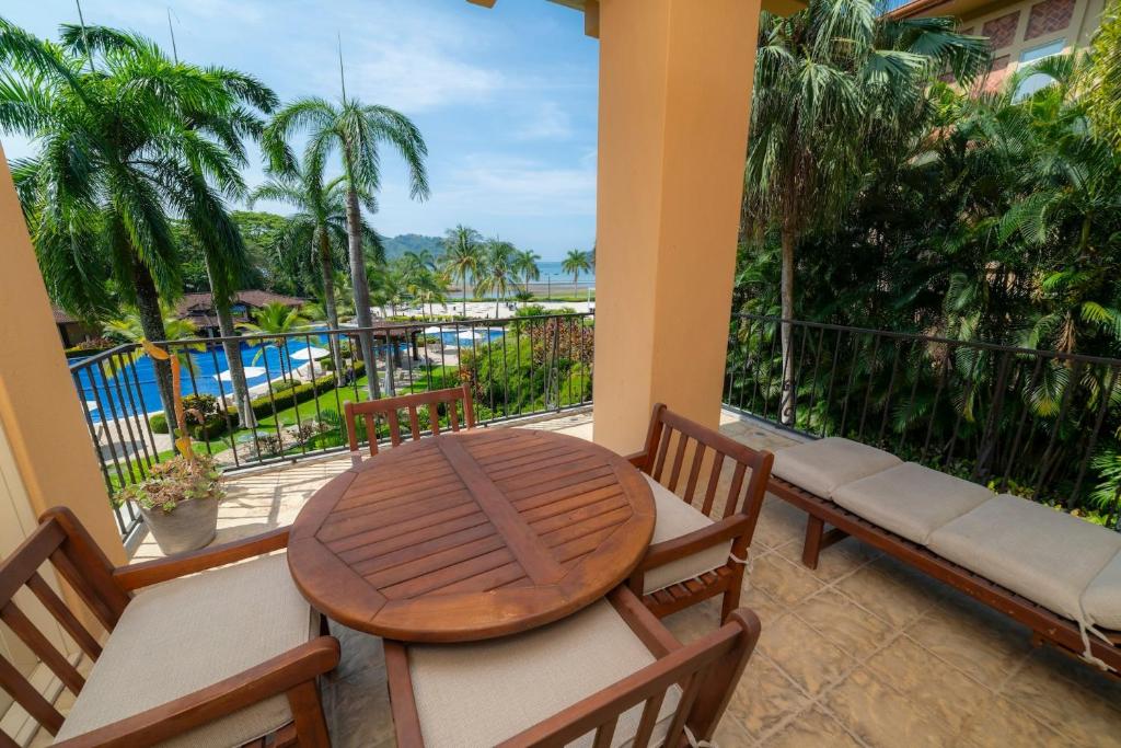 a table and chairs on a balcony with a view of a pool at Bella Vista 3C 3 bdrs ocean view in Los Suenos in Isla Herradura