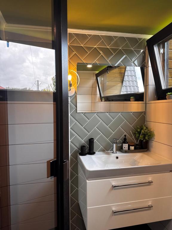 a bathroom with a sink and a mirror at A-frame-hub in Slavske