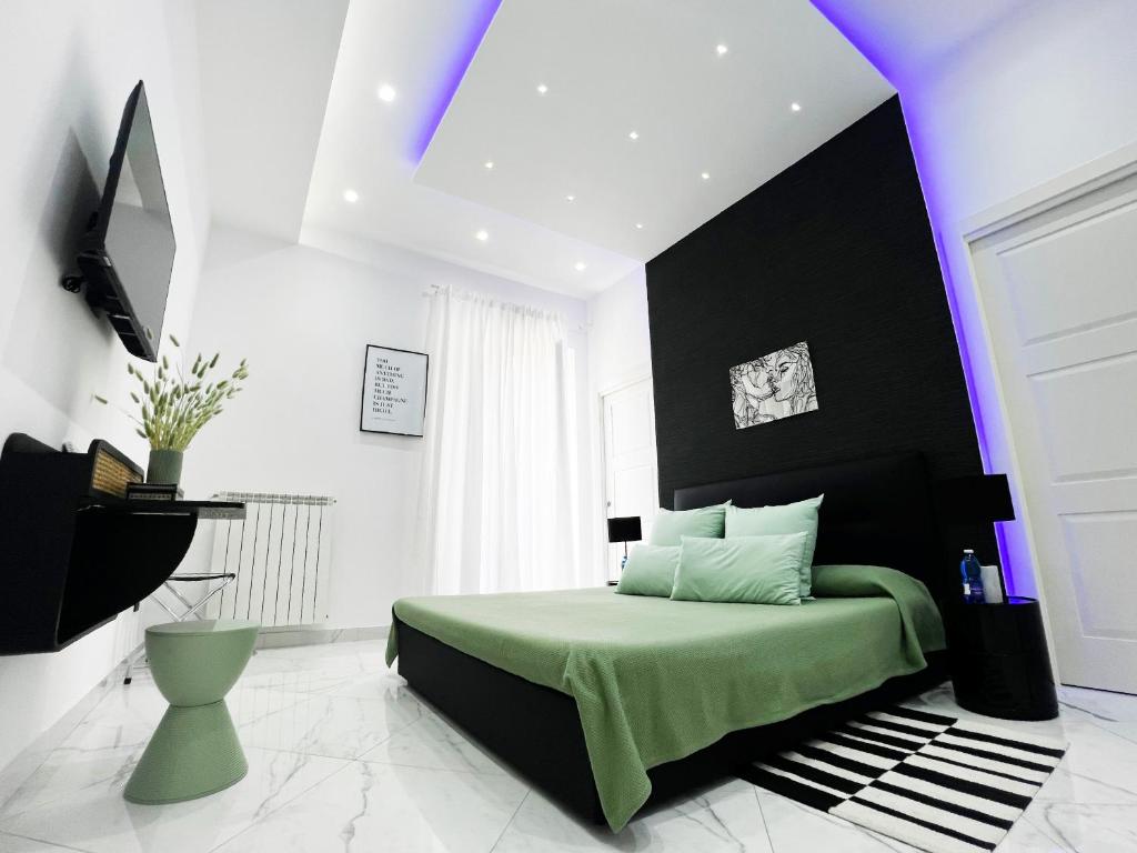 a black and white bedroom with a green bed at Veneto White Suite in Torre del Greco