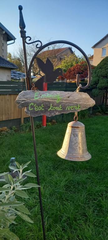 eine Glocke, die auf einer Bank in einem Hof sitzt in der Unterkunft La Valériane in Moyeuvre-Grande