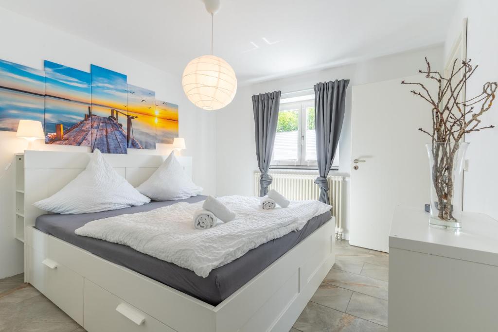 a bedroom with a large bed with a painting on the wall at Bodensee Gateway - Stockach in Stockach