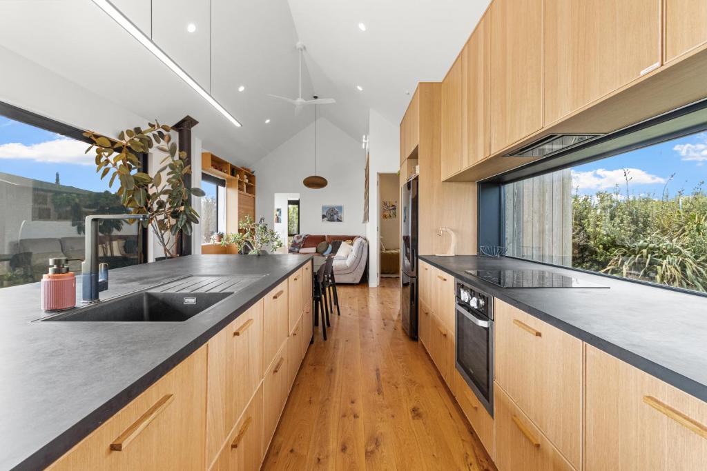 a kitchen with wooden cabinets and a large window at Seafront, Sauna, Architecture The Surf Nest Full House 