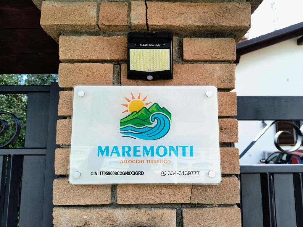 a sign on a brick wall with a cell phone at MAREMONTI alloggio turistico in Formia