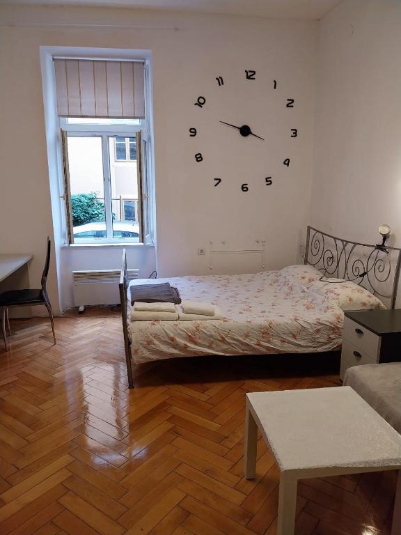 a bedroom with a bed and a clock on the wall at CENTRAL 4 U Zagreb in Zagreb