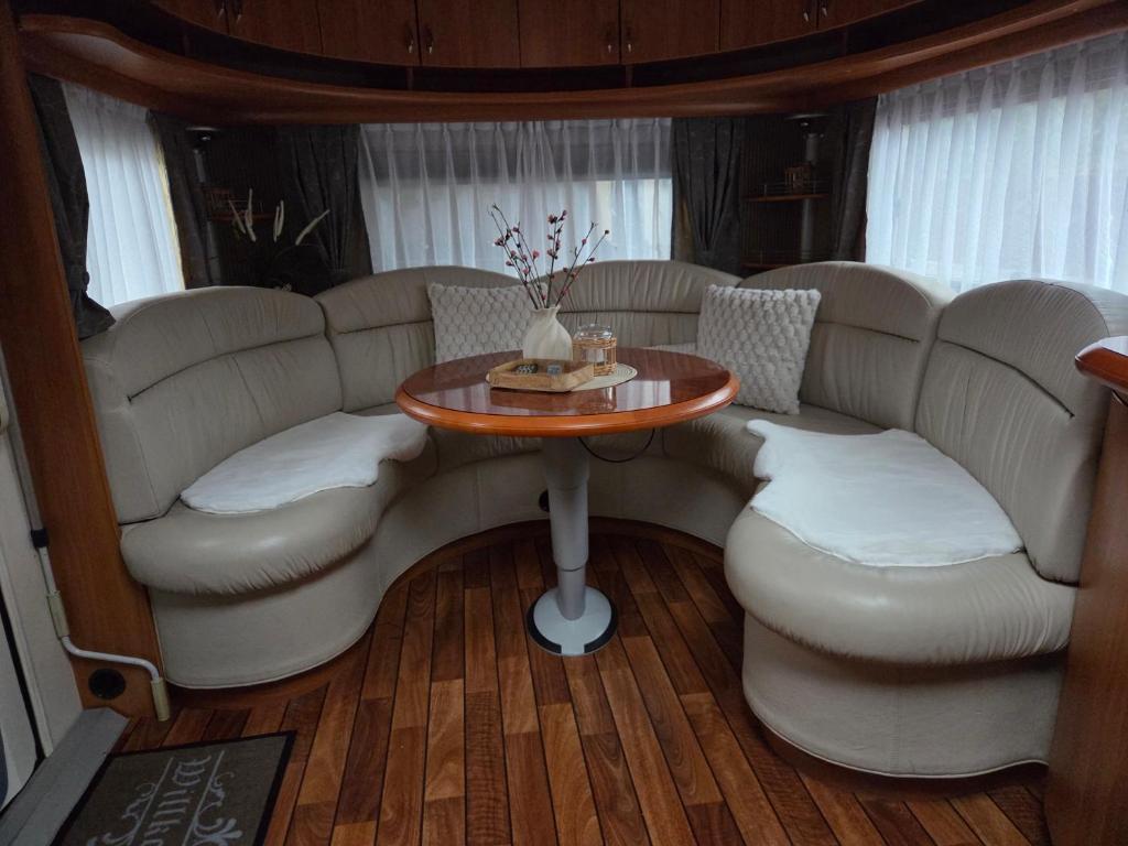 a living room with white couches and a table and chairs at Feriencamp Familie Lange - Primc in Radensdorf