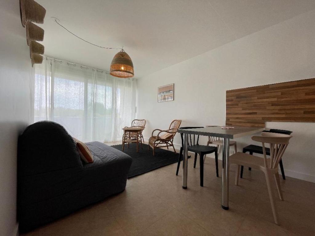 un salon avec une table, des chaises et un canapé dans l'établissement Côté Thalasso, à Quiberon