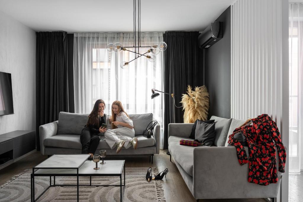 Hotel Scala City Center Apartments with Parking by Lion Apartments, two women are sitting in a living room at Scala City Center Apartments with Parking by Lion Apartments in Gdańsk