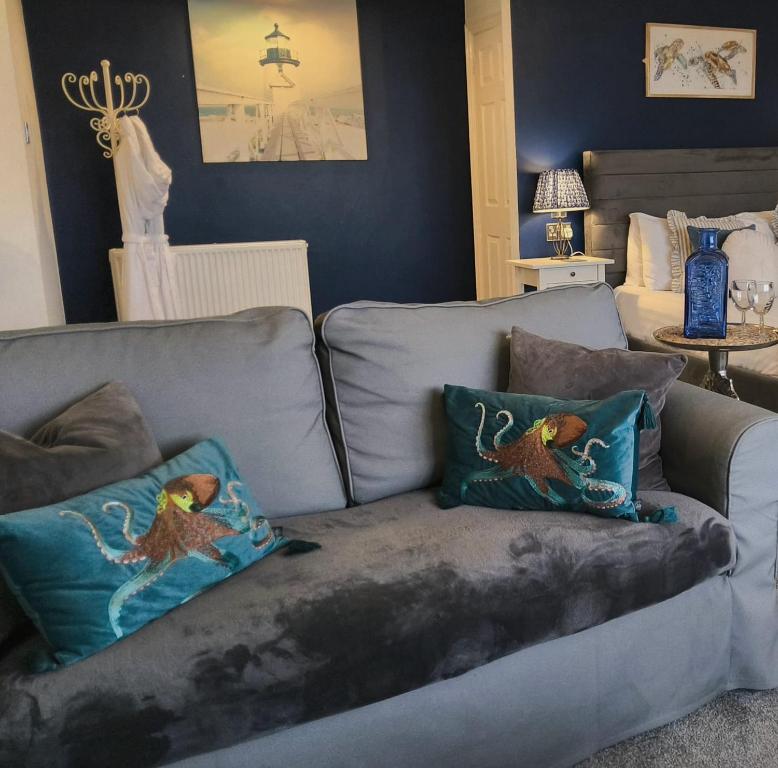 een woonkamer met een bank met twee kussens erop bij Seafarers Boutique Suites - Adults Only in Weston-super-Mare