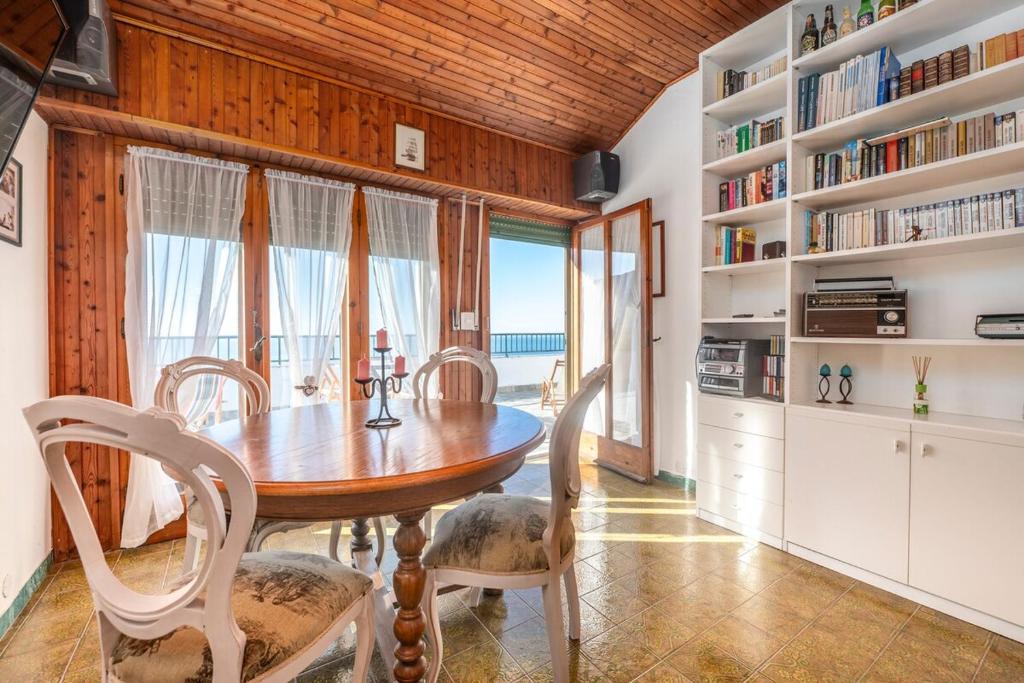a dining room with a wooden table and chairs at 322 - Crueza de Ma, Relax e Terrazza con vista sul mare di Moneglia in Moneglia