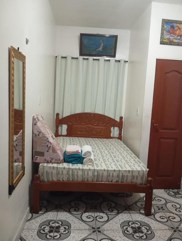 a small bedroom with a bed and a mirror at residência Cop 30 Belém do Pará in Belém