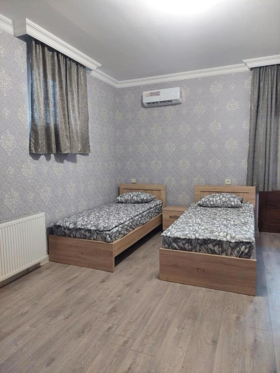 two twin beds in a room with wooden floors at gegidze 24 in Poti