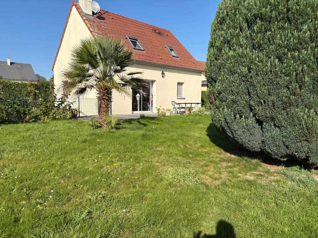 a house with a palm tree in the yard at Maison tout confort près du Mont-Saint-Michel in Saint-Quentin-sur-le-Homme