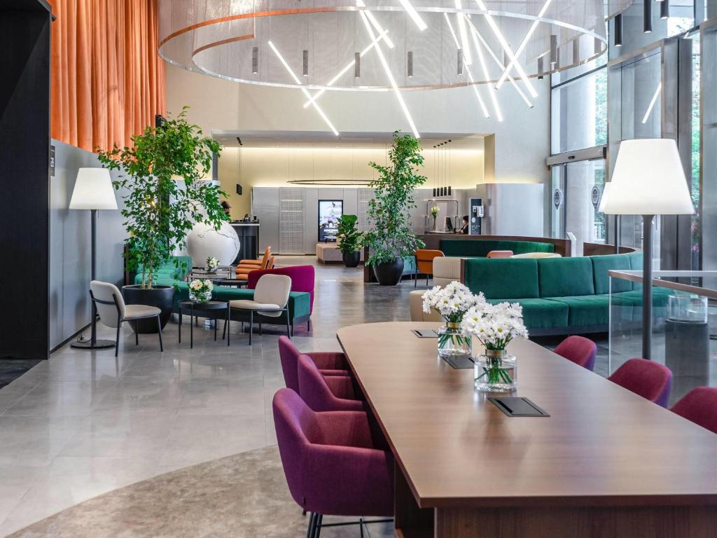 a lobby with a table and purple chairs at Pullman Santiago Vitacura in Santiago