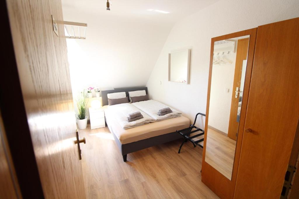 ウルムにあるCityStayOne - Kleines Standardzimmer im Zentrum für eine einfache Übernachtung No kitchen no hotel services no reception no breakfast buffet - Of course Late check-in via self check-in high-speed WiFi smart TV good mattresses a quick and easy check-outのベッドと鏡のある小さな寝室