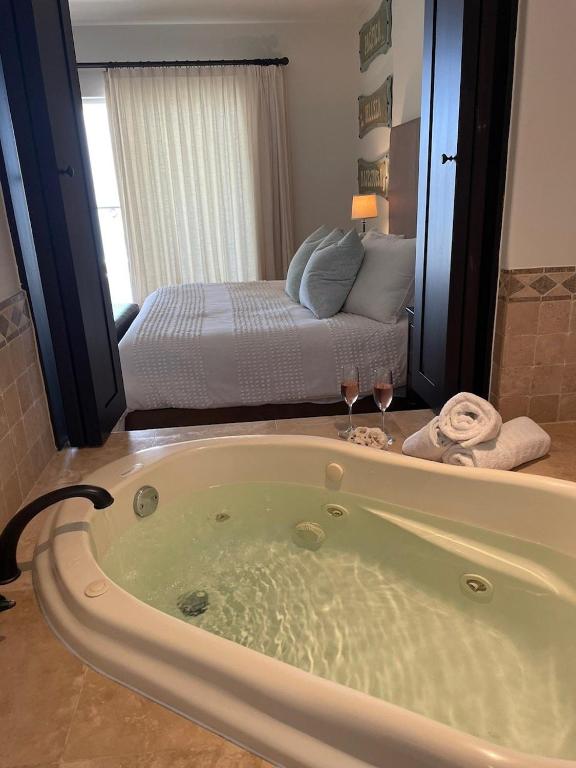 a bath tub with two wine glasses in a bedroom at Tortuga Bay TBB 2502 in San José del Cabo