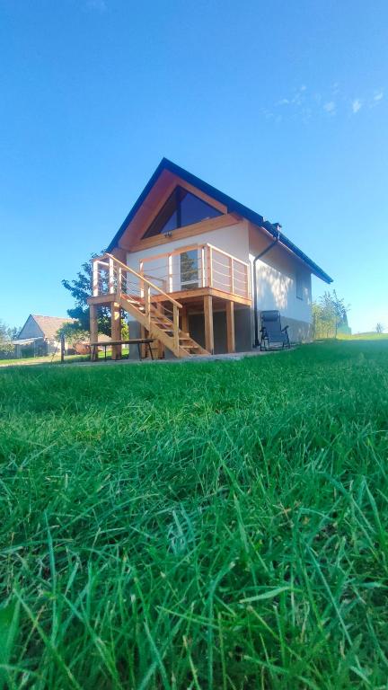a house with a grass field in front of it at Domek w Czarnusze in Augustów