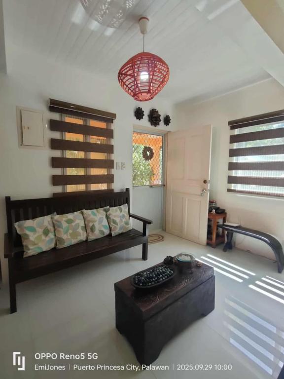 a living room with a couch and a table at Serene Home Stay in Puerto Princesa City