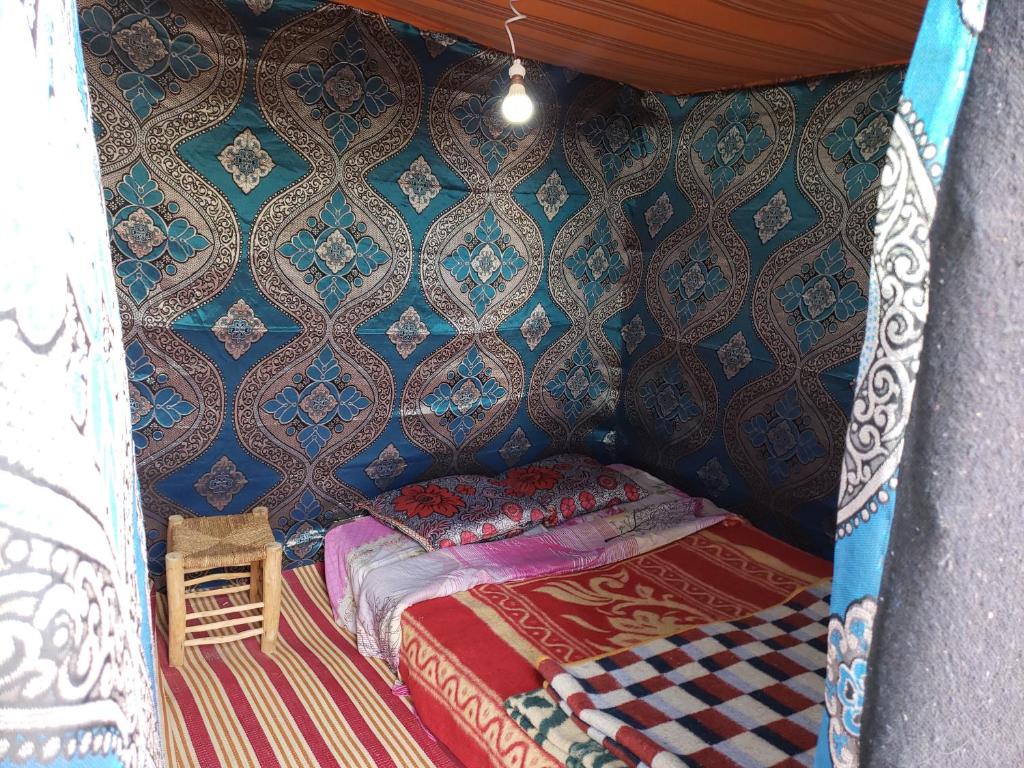 a small bed in a room with a wall at Merzouga Standard Camp in Merzouga