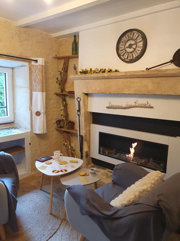 a living room with a fireplace and a table at Studio cosy & ses troglos "Chez Evariste" in La Tricherie