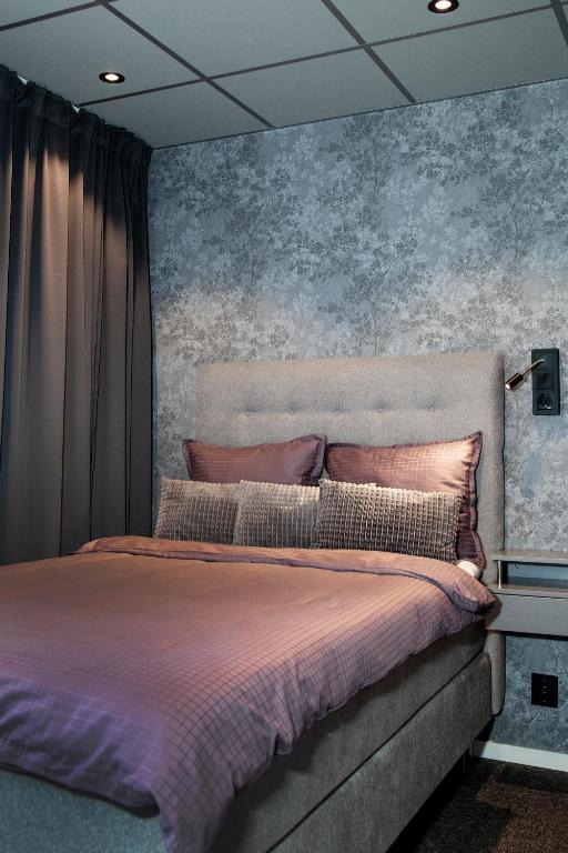 a bedroom with a large bed with purple sheets at Lägenhetshotellet Fridhem in Krylbo