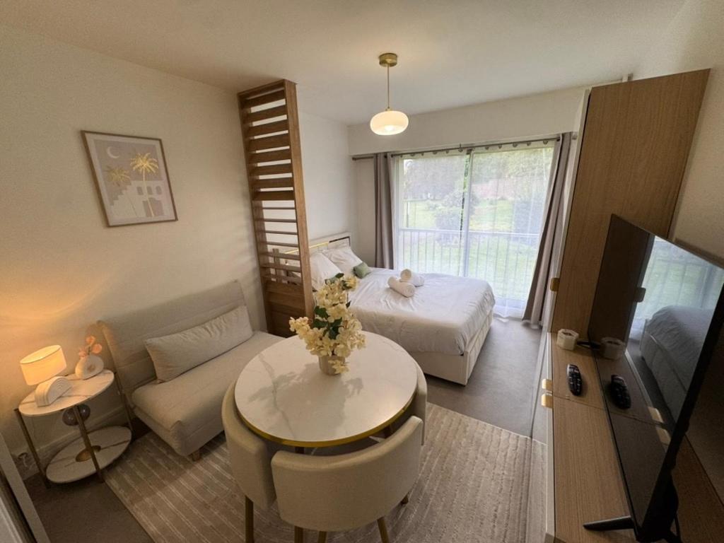 Una sala de estar con un sofá, una cama y una mesa. en Studio moderne et sécurisé, en Compiègne