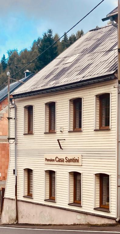 een wit gebouw met een bord waarop staat: nationaal wapen Savannah bij Casa Santini in Jáchymov