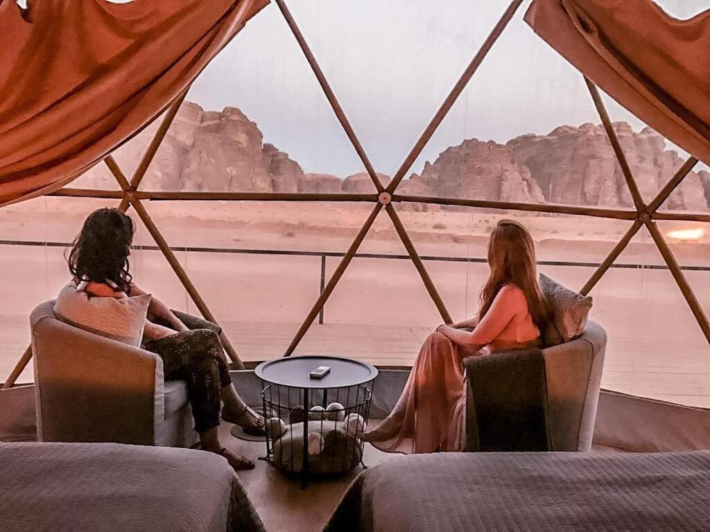 two women sitting in chairs in a tent looking out at the water at Lunar Mirage Camp in Wadi Rum