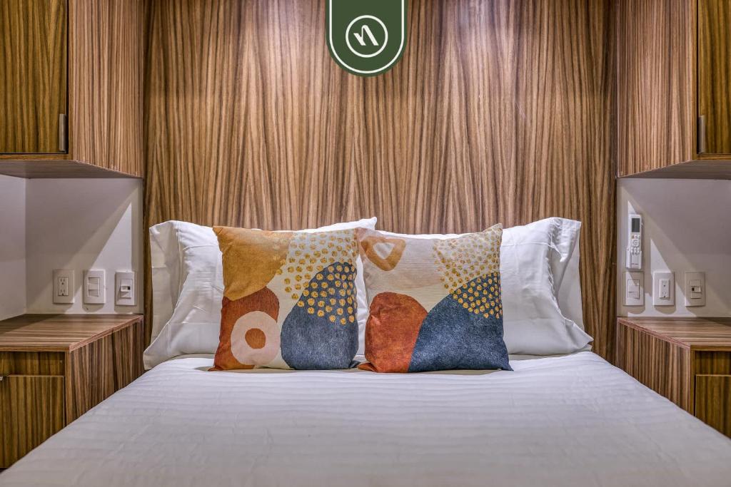 ein Schlafzimmer mit einem Bett mit Kissen darauf in der Unterkunft Brand New 1 BR Condo - Pool - Jacuzzi - Gym in Nuevo Nayarit