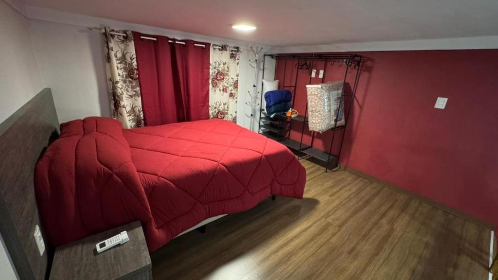 een slaapkamer met een rood bed en een rode deken bij Loft Firenze - Conforto e Estilo na Serra Gaúcha in Bento Gonçalves