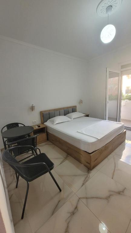 a bedroom with a bed and a table and a chair at NEAR Guest-house in Durrës