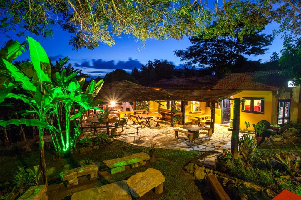 a patio with benches and tables at night at Pousada Casa da Moeda in Brumadinho