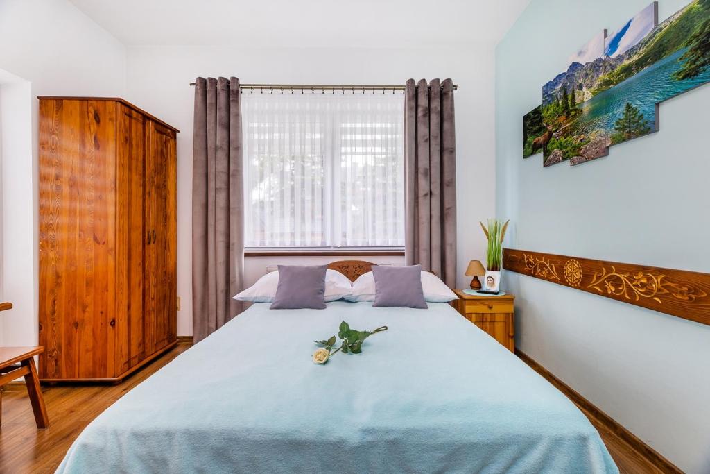 Un dormitorio con una cama grande con una manta azul. en Willa Pod Wierchem, en Bukowina Tatrzańska