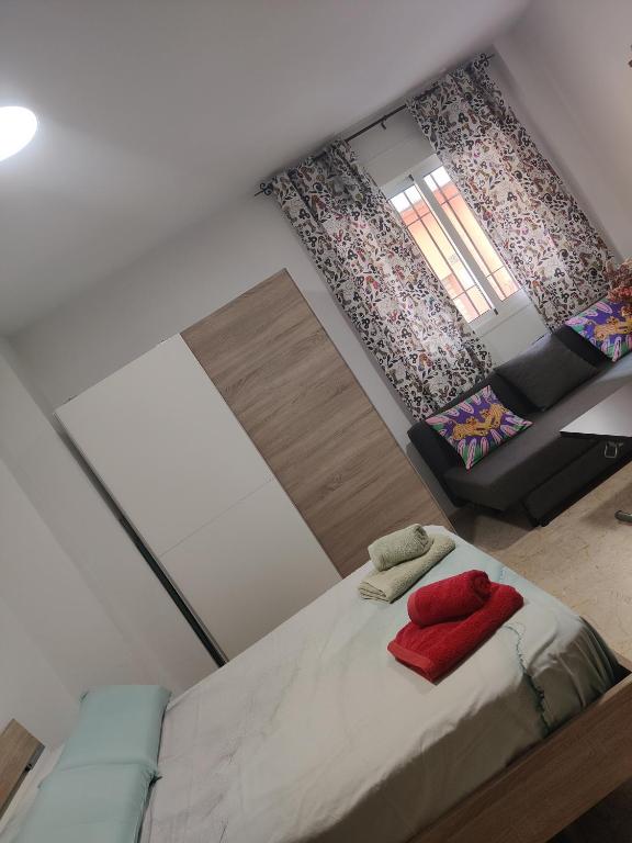 a small bedroom with a bed and a couch at playa Almería zapillo loft in Almería