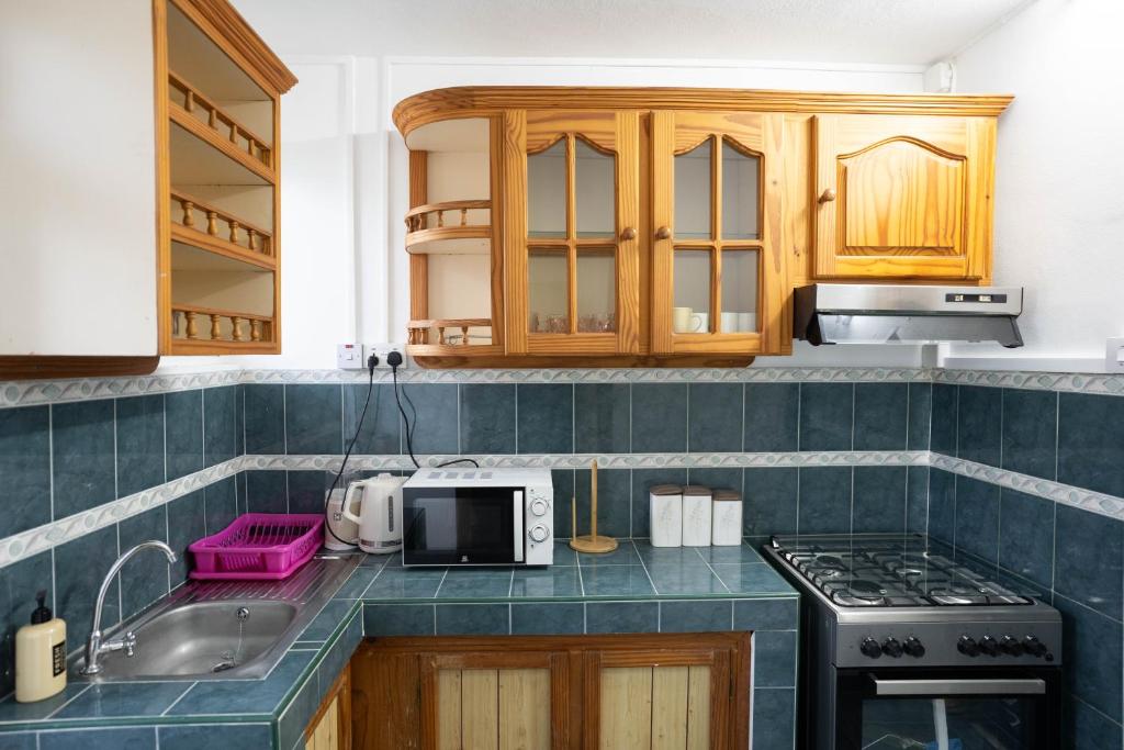 a kitchen with a sink and a stove top oven at Seaview Apartment by Beach in Flic-en-Flac