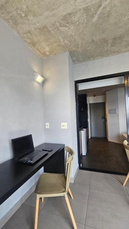 a desk with a laptop and a chair in a room at Studio espaço Bom Retiro in Sao Paulo