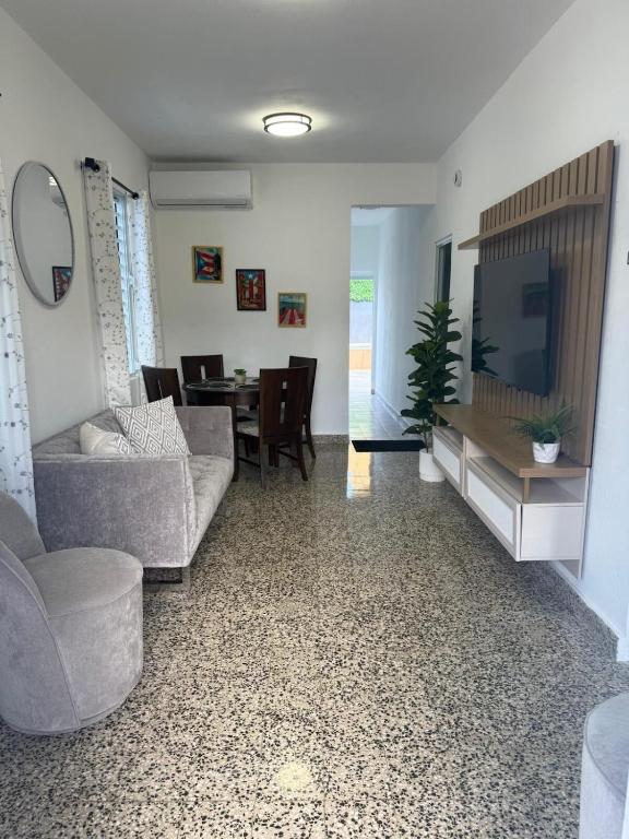 a living room with a couch and a tv and a table at House with pool and close to everything in San Juan