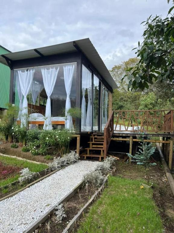 a house with white curtains on the side of it at Pazionart Chalets in Santa Elena