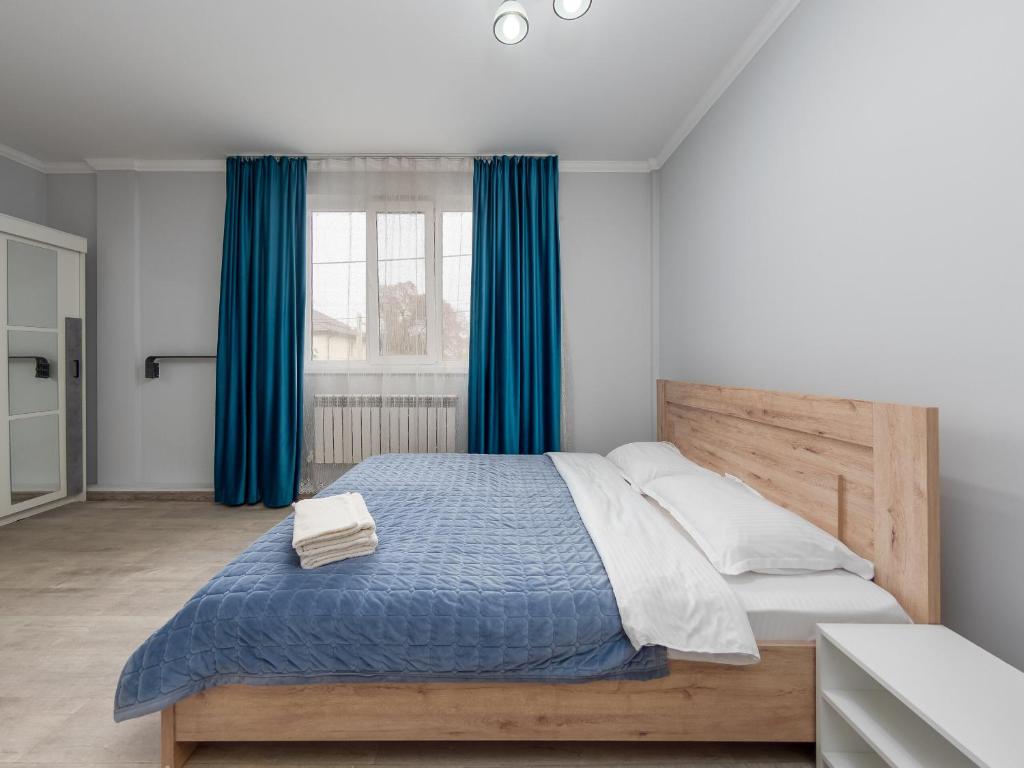 アルマトイにあるZhetysu Apartment on Sayahatのベッドルーム1室(青いカーテン付きの大型ベッド1台付)