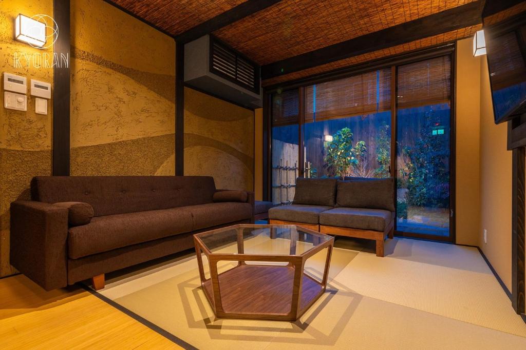 ein Wohnzimmer mit einer Couch und einem Glastisch in der Unterkunft Kyoran [Shion Residence] - Vacation STAY 69064v in Kyōto