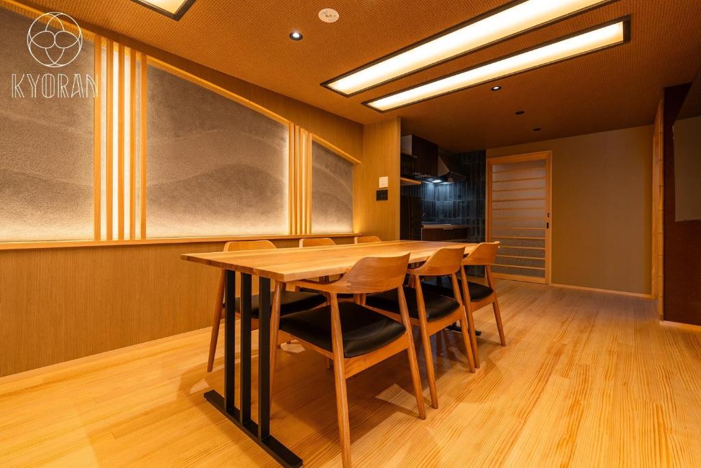 ein Esszimmer mit einem Holztisch und Stühlen in der Unterkunft Kyoran [Fuji Residence] - Vacation STAY 69041v in Kyōto