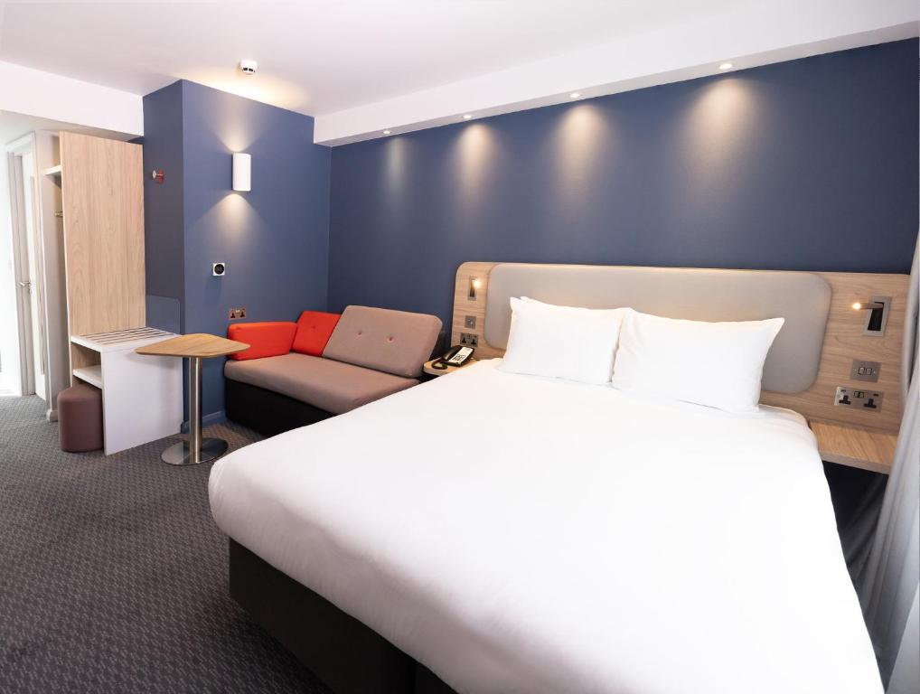a hotel room with a large bed and a couch at Holiday Inn Express Windsor by IHG in Windsor
