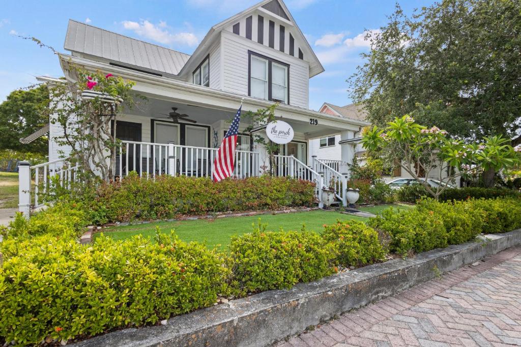 una casa blanca con una bandera americana delante de ella en The Porch at Fort Pierce, en Fort Pierce