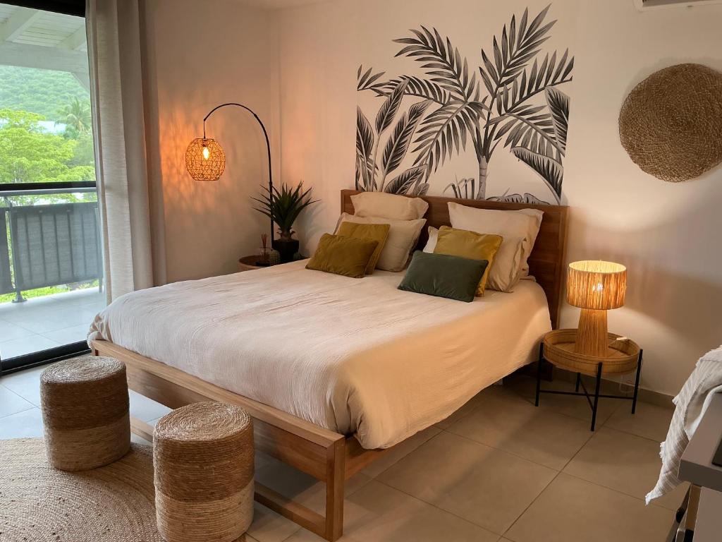 une chambre avec un grand lit et un tableau de plante au mur dans l'établissement Kalista - Studio Luxueux - Anse Marcel, à Saint-Martin