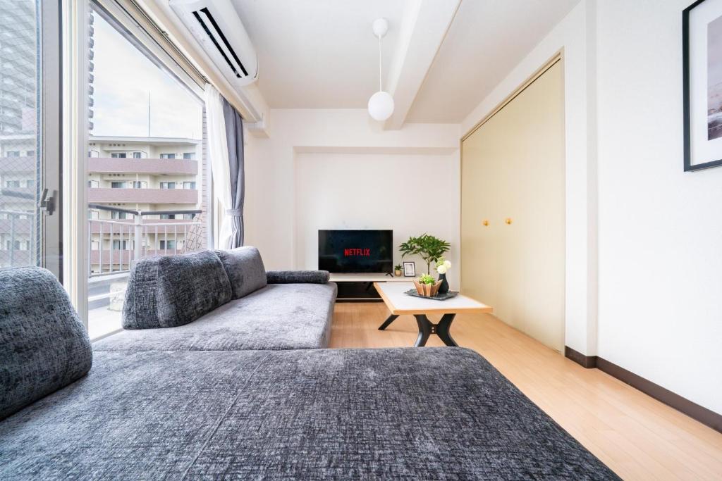 a living room with a couch and a tv at Nakajima Park Mansion - Vacation STAY 20417 in Toyohira