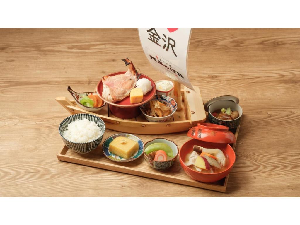 - un plateau de nourriture avec des sushis et du riz sur une table dans l'établissement Smile Hotel Premium Kanazawa Higashiguchi Ekimae - Vacation STAY 73592v, à Housai