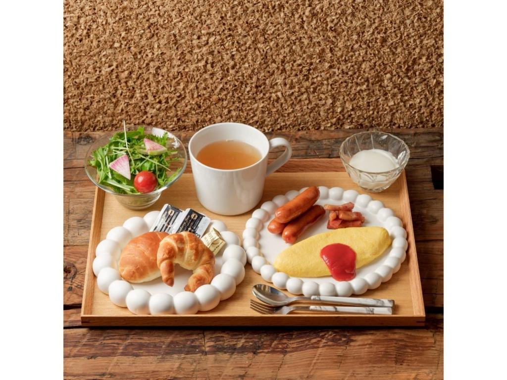 un plateau avec deux assiettes de nourriture et une tasse de thé dans l'établissement Smile Hotel Premium Kanazawa Higashiguchi Ekimae - Vacation STAY 73601v, à Housai
