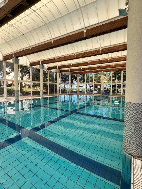 a large swimming pool with blue tiles in a building at Rose Suite in Caesarea